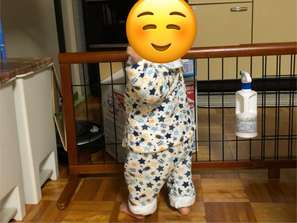 ベビーガードにつかまり立ちしている赤ちゃん