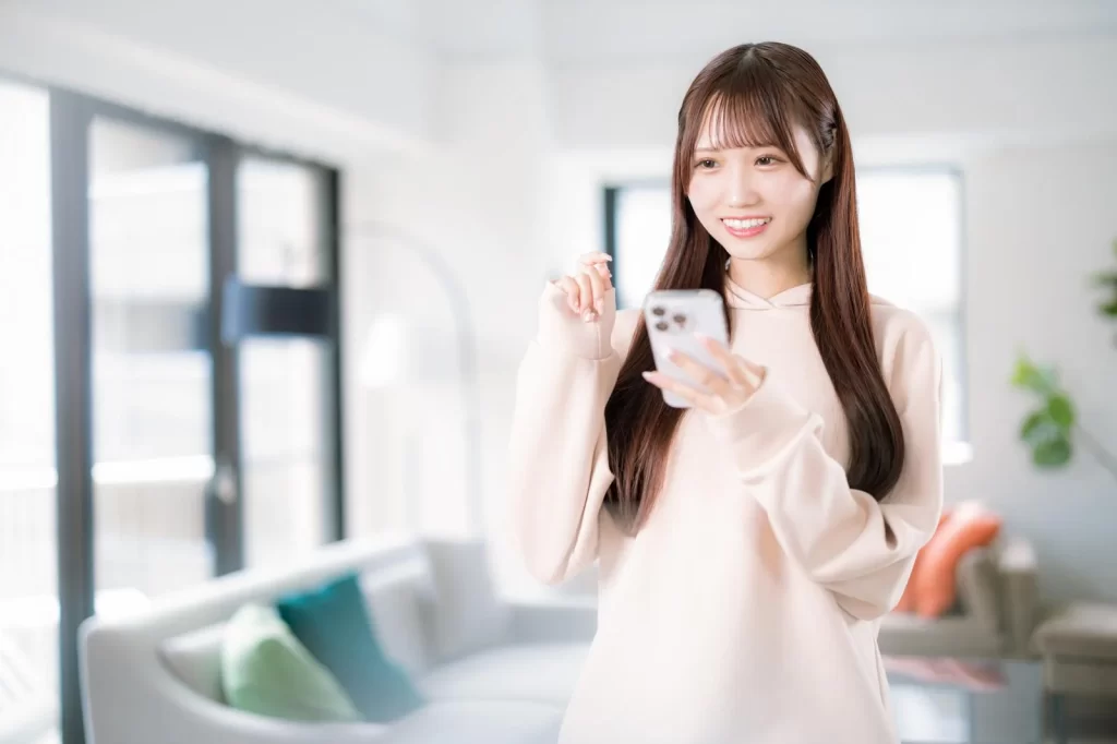 スマートフォンを眺めてほほ笑む女性